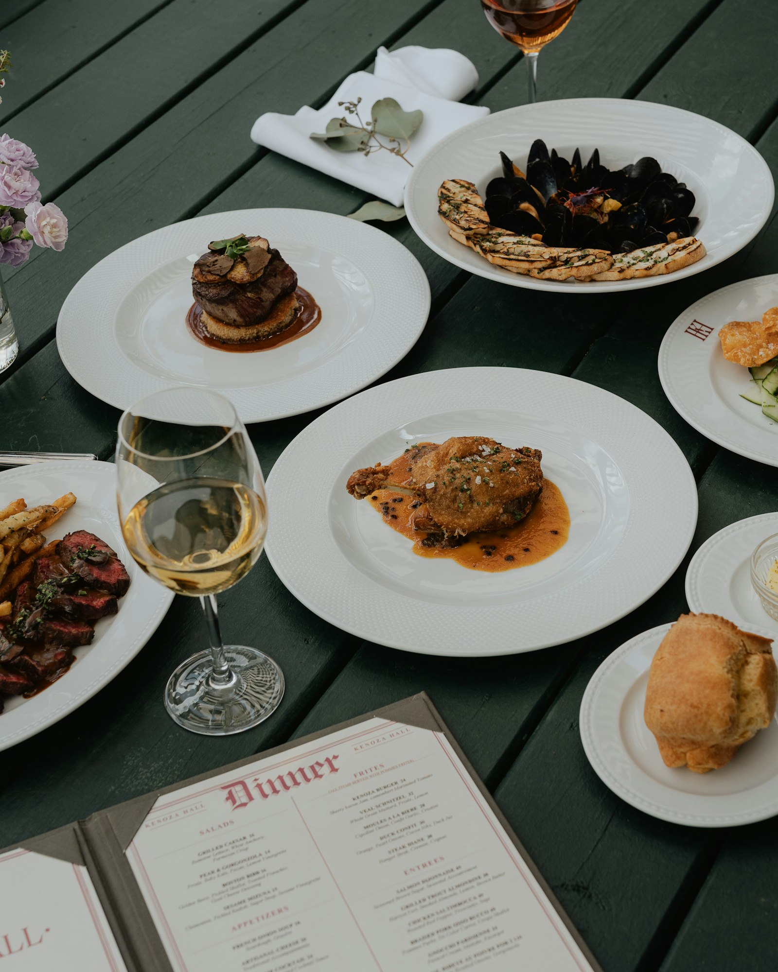 A restaurant table set with plated food and a glass of wine, the revenue side of the business